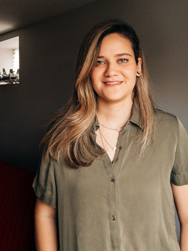 Retrato da Bianca, com um sorriso, olhando para camera.