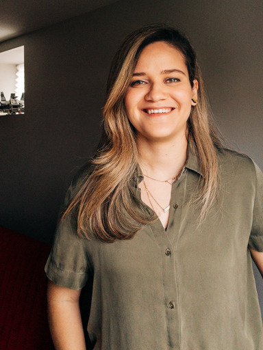Retrato da Bianca, com um grande sorriso, olhando para camera.