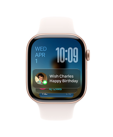 R??ově zlaté Apple Watch Series?11 se světle ruměnym ?emínkem, v levém horním rohu ciferníku se zobrazuje datum, vpravo naho?e ?as a dole widget Zprávy