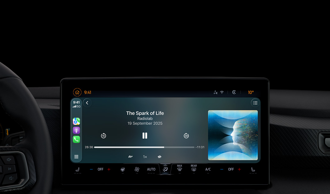 汽車內(nèi)部，中央控制臺(tái)顯示器顯示 Apple Podcast 透過(guò) CarPlay 播放，正在播放 Radiolab 的 podcast《The Spark of Life》，播放控制項(xiàng)目包括倒轉(zhuǎn)、暫停和快轉(zhuǎn)。