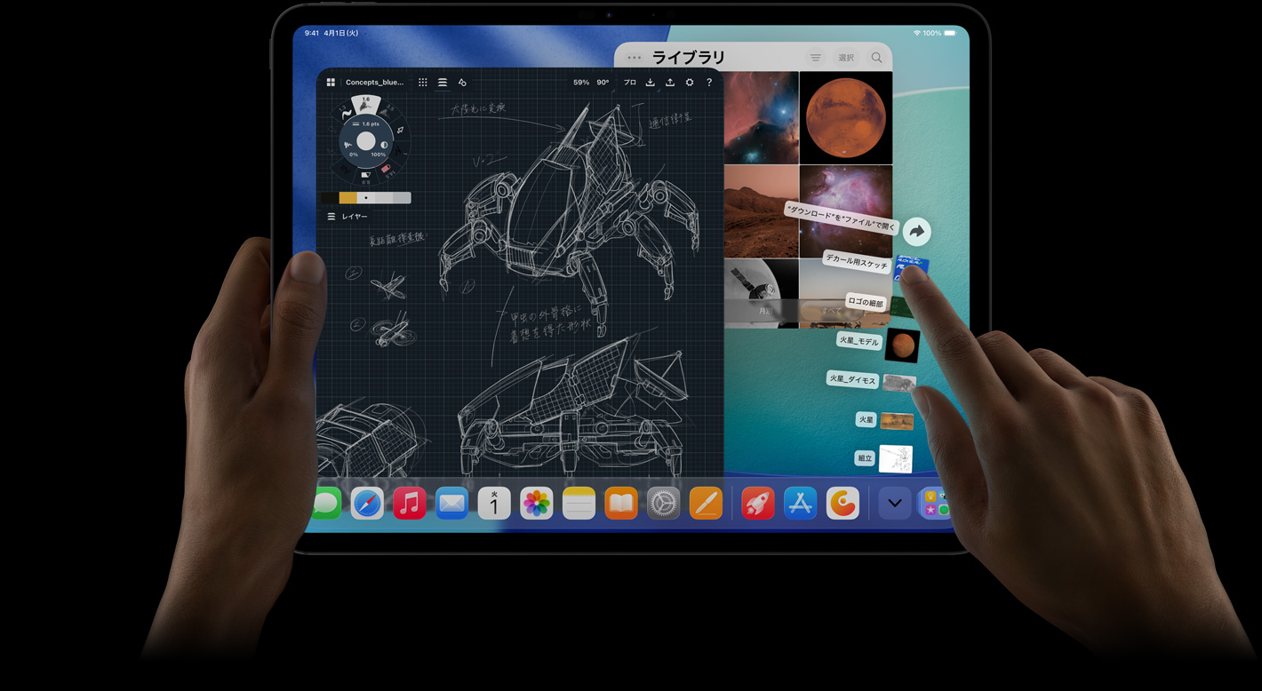 iPad Proの前面の外観、橫向き、ダウンロードフォルダから扇狀に広がったファイルを指差している右手。ディスプレイにはiPadOS 26のインターフェイスが表示されており、ロボットの詳細な設(shè)計図、手書きの注釈、複數(shù)のデザイン工程を表示した寫真編集アプリ、寫真ライブラリなど、複數(shù)のアプリが開かれている