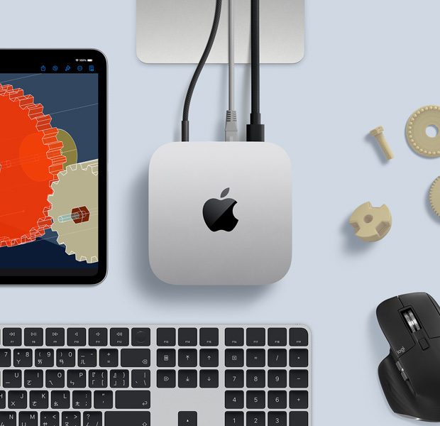 擺放在桌面的銀色 Mac mini 俯視圖，旁邊放著黑色配銀色的無線鍵盤、黑色無線滑鼠和一部 iPad