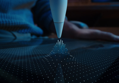 Un Apple Pencil Pro pointe vers le bas en direction d’un écran. L’écran est recouvert de points qui se soulèvent en suivant la pointe de l’Apple Pencil Pro, montrant la fa?on dont le survol avec l’Apple Pencil relie l’Apple Pencil Pro à l’iPad avant même qu’il en touche la surface.